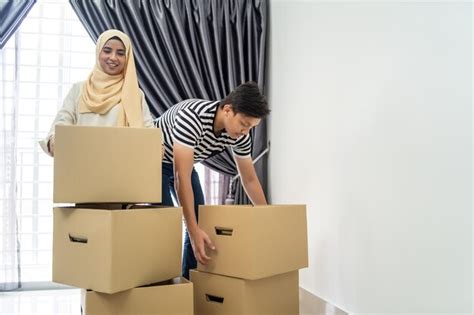 Premium Photo Couple Holding Cardboard Boxes While Standing At New Home