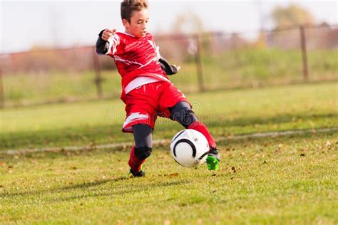 Futebol De Retrocesso Do Menino No Campo De Esportes Imagem De Stock