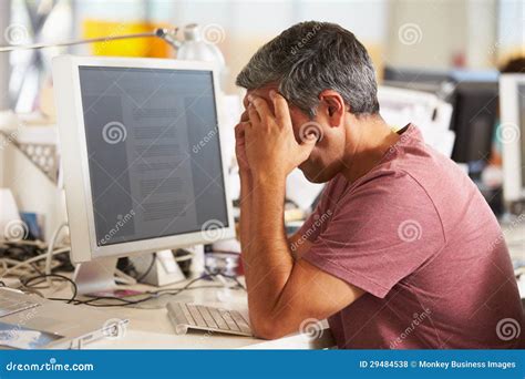 Stressed Man Working at Desk in Busy Creative Office Stock Photo ...