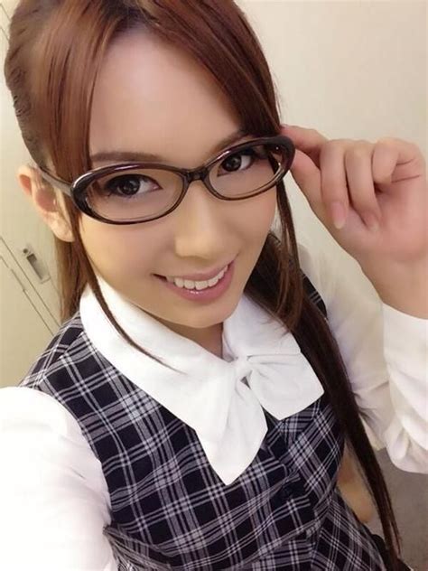 A Woman Wearing Glasses And A Bow Tie Posing For The Camera With Her