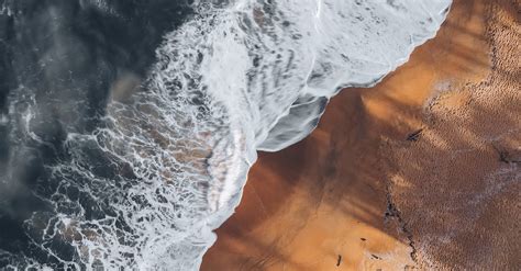 An Aerial Photography Of Waves Crashing On Brown Sand · Free Stock Photo