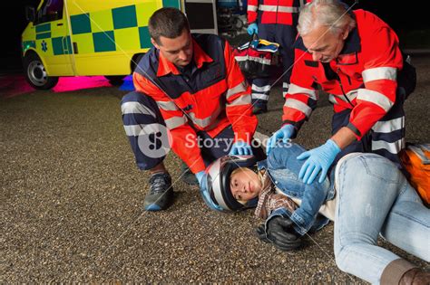 Paramedics Helping Injured Motorbike Woman Driver Lying On Road Night