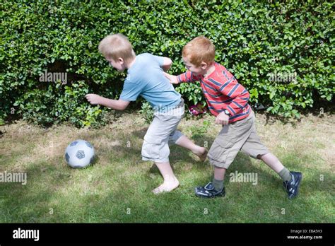 Two brothers playing football in the garden Stock Photo - Alamy