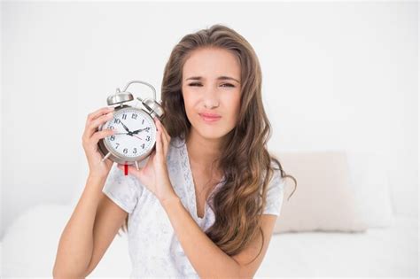 Premium Photo Upset Pretty Brunette Holding Alarm Clock