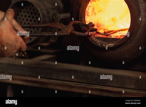 Close Up Working Powerful Hands Of Male Blacksmith Making Red Hot Metal In Furnace Horn Work