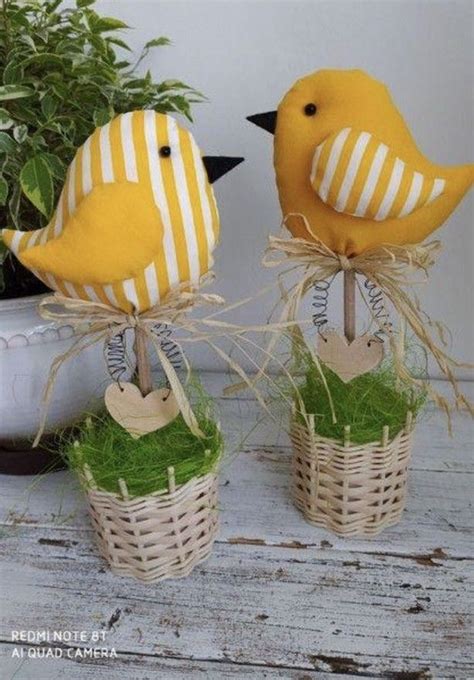 Two Yellow Birds Sitting On Top Of Grass In Small Baskets Next To A