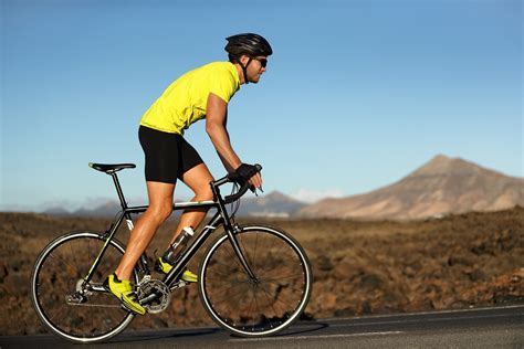 Biking Cyclist Male Athlete Going Uphill On Open Road Training Hard On