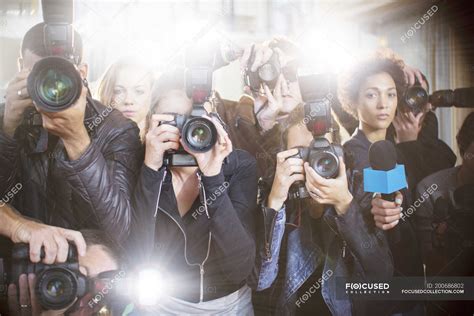 Porträt seriöser Paparazzi-Fotografen, die Kameras zeigen — Frauen ...