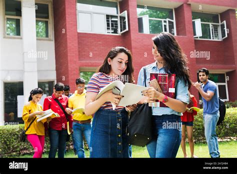 Two Young Girls College Student Friends Together Reading Book And