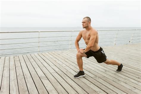 Premium Photo Muscular Man With A Naked Torso Doing Leg Stretch