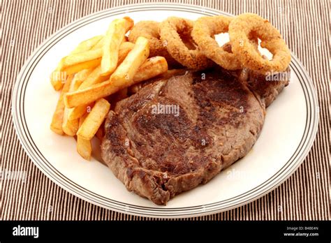 Freshly Cooked Sirloin Beef Steak With Chips And Onion Rings Isolated