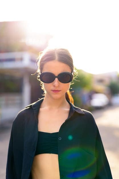 Premium Photo Portrait Of Young Woman Wearing Sunglasses Standing Outdoors