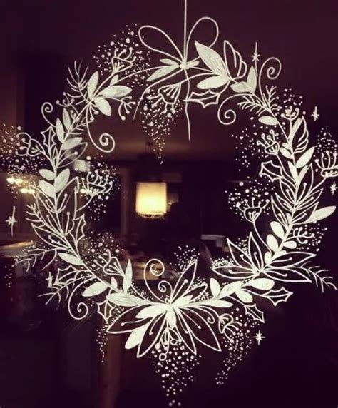 A White Christmas Wreath Hanging From The Side Of A Door With Stars And