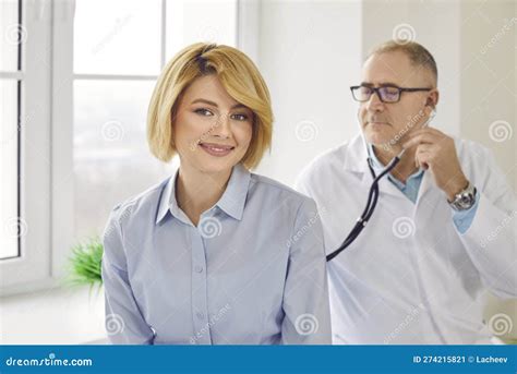 Mature Patient In Clinic For Checkup Doctor With Stethoscope Examining Woman S Lungs And
