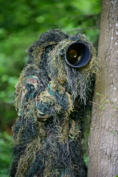 Fotógrafo de vida silvestre en el traje de camuflaje ghillie verano