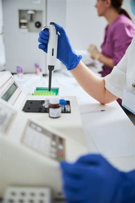 Experienced Biochemist Using A Hematology Analyzer For A Blood Analysis