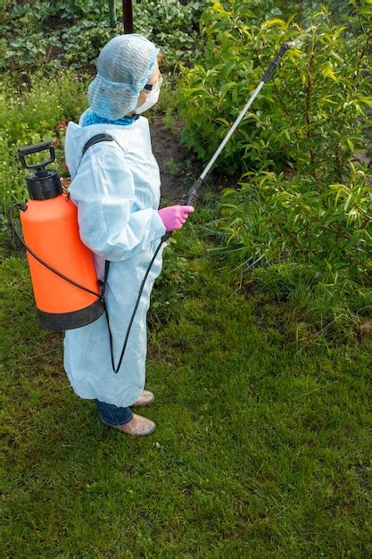 Premium Photo Farmer In A Protective Suit Is Spraying Apple Trees