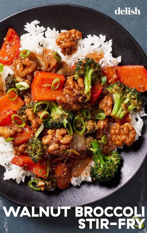 A Black Plate Topped With Broccoli Carrots And Meat On Top Of Rice