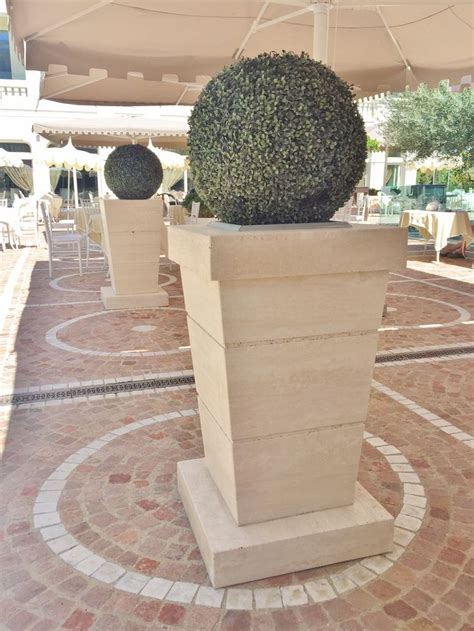 A Large Potted Plant Sitting On Top Of A Stone Block In The Middle Of A