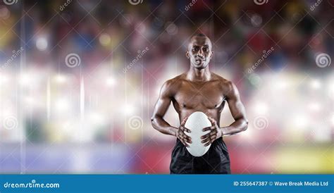 Composition Of Shirtless Male Rugby Player Holding Rugby Ball Over