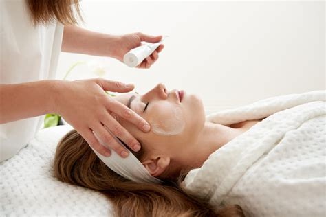 Premium Photo Cosmetologist Applying Cream On Female Face Woman