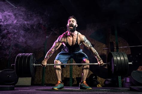 Hombre De Fitness Muscular Haciendo Peso Muerto De Una Barra En El