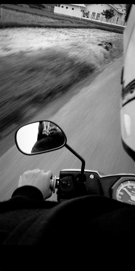 A Person On A Motor Bike Driving Down The Road In Front Of A Rear View