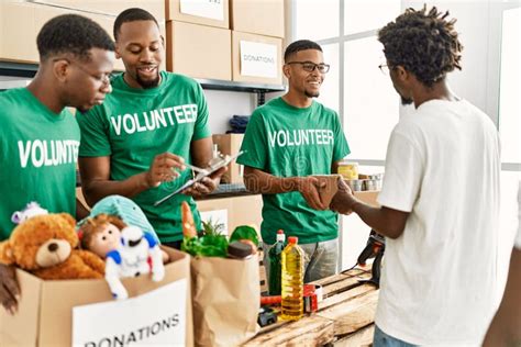 Group of Young African American Volunteers Helping People at Charity ...