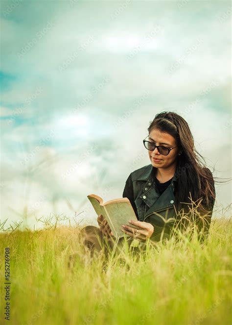 Smiling Girl Reading A Book In The Green Field Teen Girl Sitting On