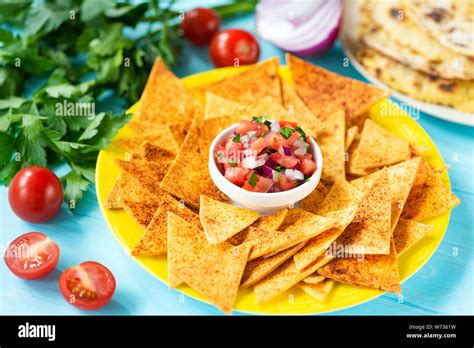 Corn Tortilla Chips Nachos With Paprika And Tomato Salsa On Plate Blue