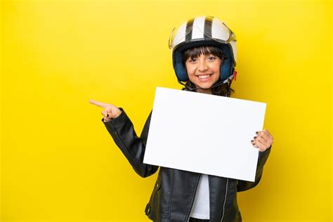 Mujer Latina Joven Con Un Casco De Motocicleta Aislado Sobre Fondo Amarillo Sosteniendo Un