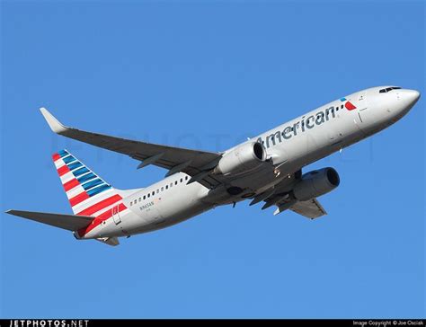 An American Airlines Plane Flying In The Sky With Its Landing Gear Down