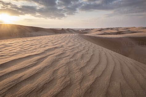 Sand Dunes At Sunset In The Wahiba Sands Desert With Clouds In The Sky