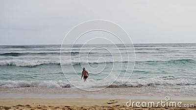 A Beautiful Landscape A Deserted Beach Far Away A Naked Man Approaches The Ocean Slow Motion