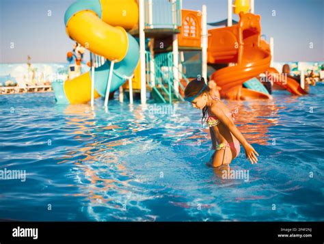 Fröhliches Mädchen in einem hellen Badeanzug und blau schwimmen