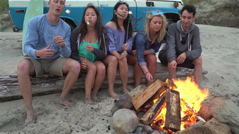 Group of friends at beach hanging out by campfire 2569559 Stock Video ...