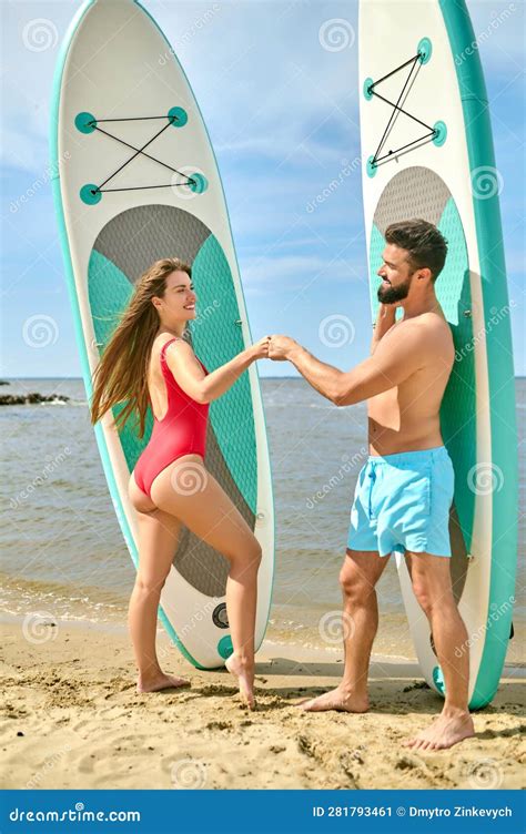 Couple With Surfboards Man And Woman In Swimsuits Doing Fist Bump