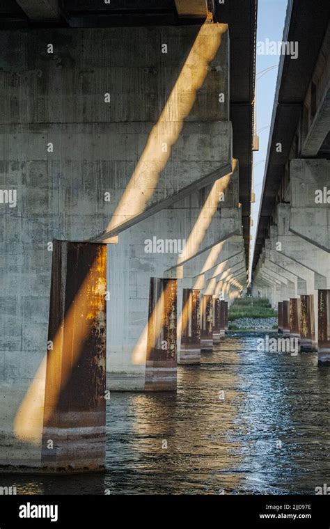 Under A Commuter Bridge With Pillars In Water On A Sunny Summer Morning