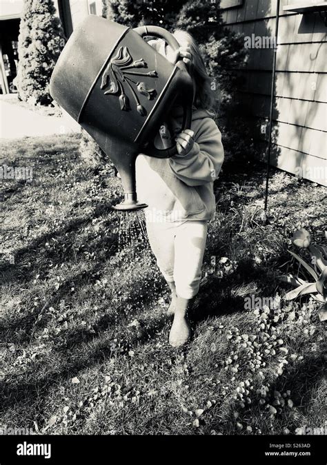 Girl using watering can Stock Photo - Alamy