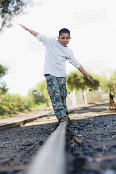 Boy Walking On Railroad Track Stock Photo Dissolve