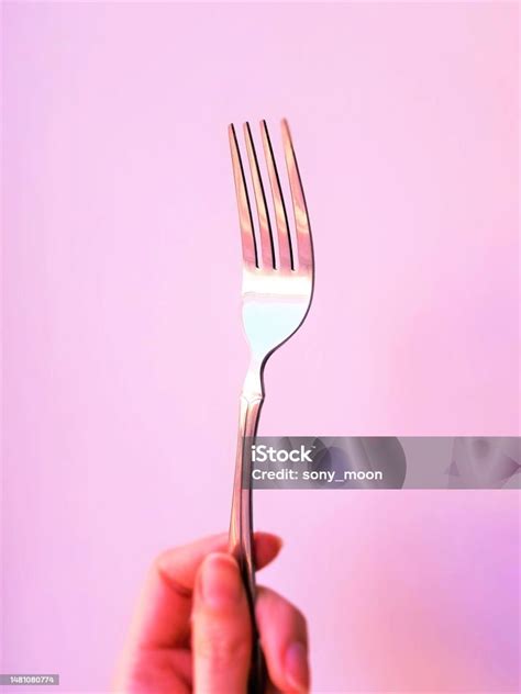 Silver Fork In Young Female Fingers Closeup Pink Tone Stock Photo