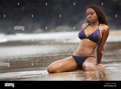 Une Jeune Femme Noire Voluptueuse Dans Un Bikini Violet Se Trouve Sur