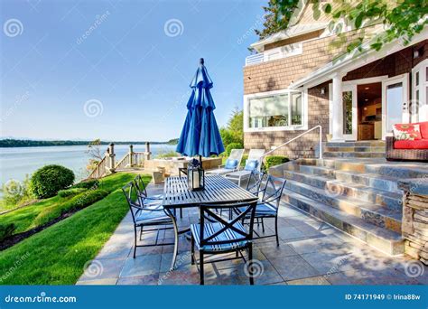 Luxury House Exterior With Impressive Water View And Cozy Patio Area