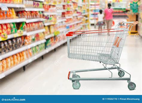 Supermarket Aisle With Empty Shopping Cart At Grocery Store Stock Photo