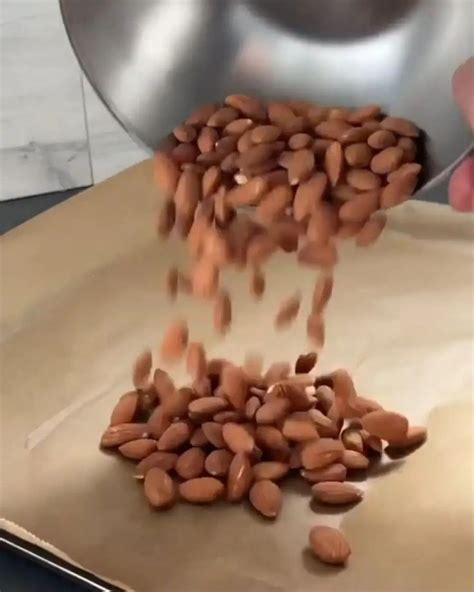 A Person Is Pouring Peanuts Into A Pan