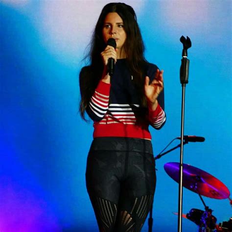 A Woman Standing In Front Of A Microphone On Stage