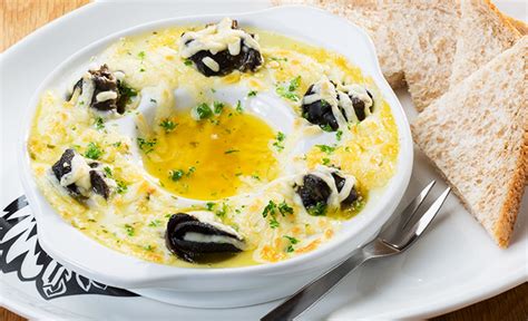 A White Plate Topped With A Bowl Of Soup And Two Slices Of Bread On Top