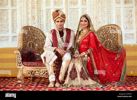 Indian Bride And Groom In Traditional Wedding Dress Sitting On A Stock