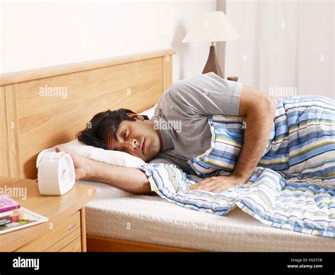 Young Man Sleeping Lying On Bed Hand Stopping Ringing Alarm Clock Mr