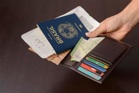 Premium Photo Hand Holding Brazilian Passport Over Table